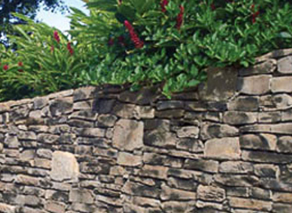 Wall built using Del Mare Ledgestone with plants peeking over it